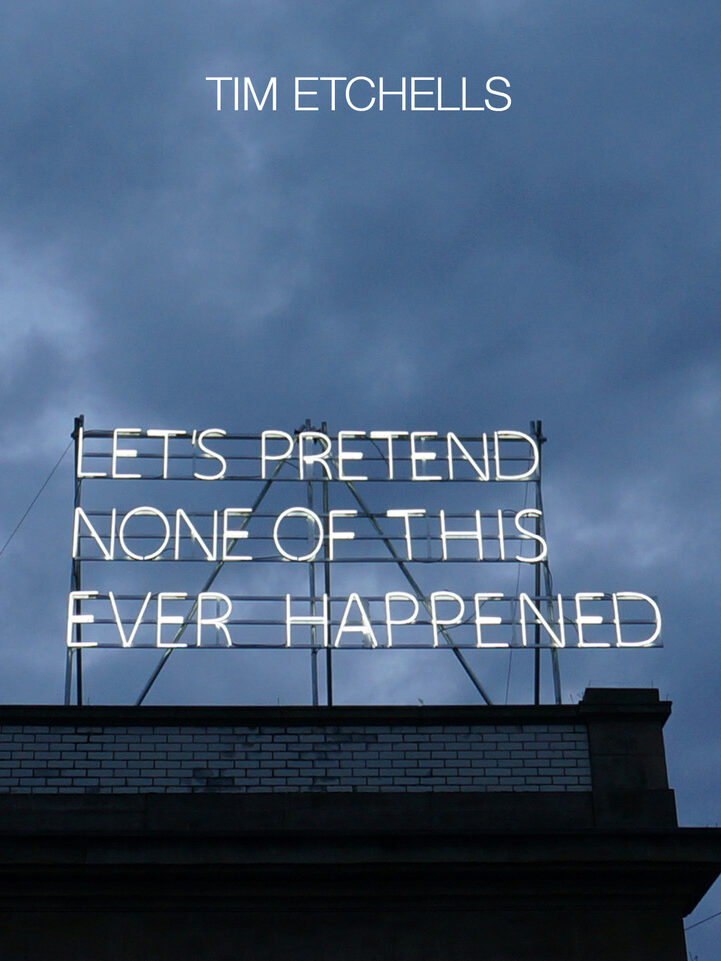 White neon letters on top of a building infront of a cloudy sky reads 'Lets pretend none of this ever happened'.